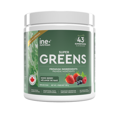 A white plastic tub of ine nutrition Super Greens powder with a green label, featuring illustrations of mixed berries and a Canadian maple leaf, on a white background.