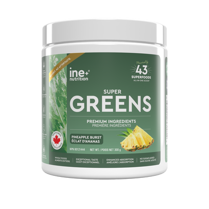 A white plastic tub of ine nutrition Super Greens powder with a dark green label, featuring pineapple graphics and text for Pineapple Burst flavor.